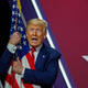 Donald Trump wrapping himself over the flag at CPAC on Feb. 29, 2020.